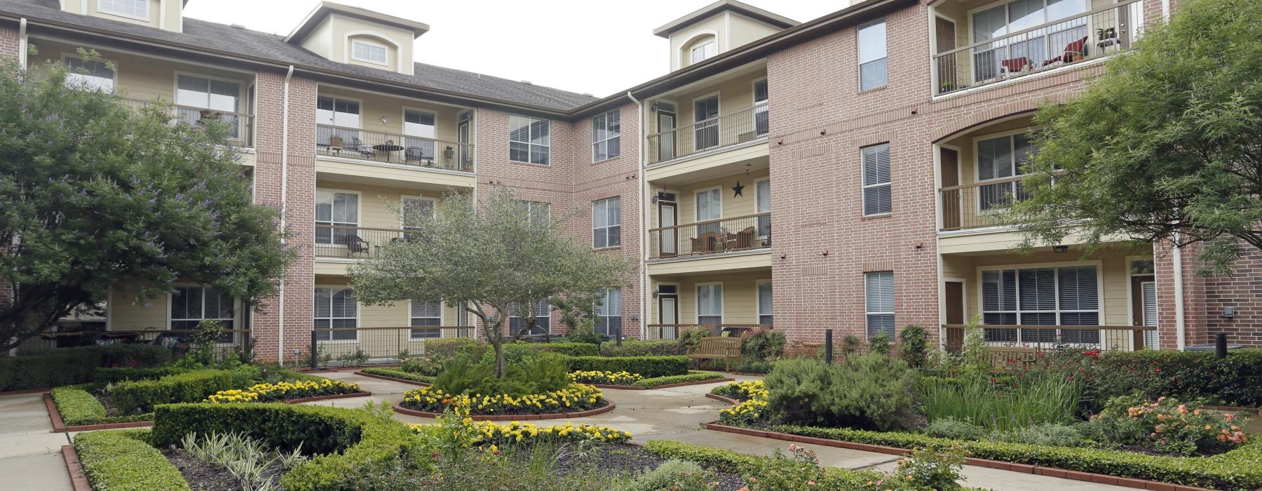 a courtyard with trees and plants in front of a building
