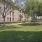 a large brick building with trees and grass in front of it