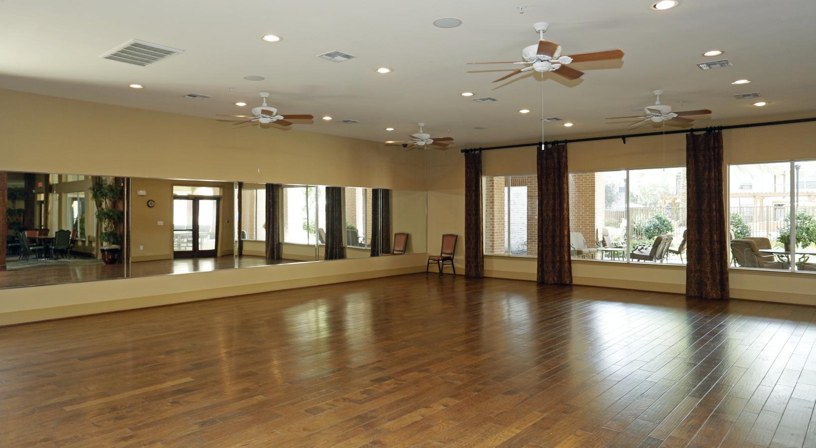 Take advantage of all Elate Royal Oaks has to offer a large room with a wood floor and a wall of mirrors and windows