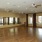 a large room with a wood floor and a wall of mirrors and windows