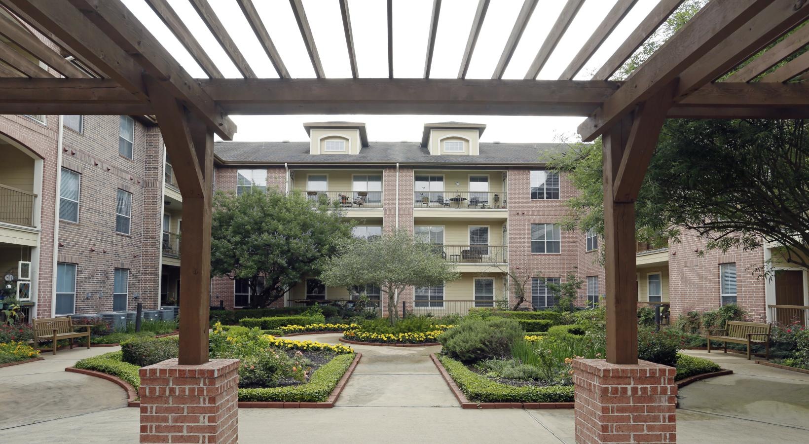 The essence of exceptional living a courtyard with a brick walkway and trees and a building in the background