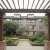 a courtyard with a brick walkway and trees and a building in the background
