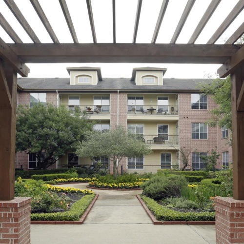 The essence of exceptional living a courtyard with a brick walkway and trees and a building in the background