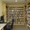 a room with a desk a computer and full bookshelves