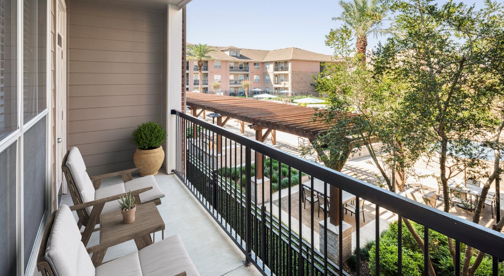 Settle into comfort at Elate Royal Oaks a balcony with a railing and trees