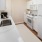 a kitchen with white cabinets a sink a fridge a stovetop